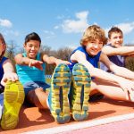 Niños realizando estiramientos tras el atletismo