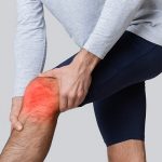 Hombre con dolor de rodilla. Rótula coloreada de rojo por edición fotográfica