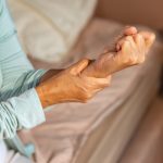 Mujer mayor se sujeta la muñeca ante un dolor intenso