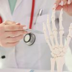 Mujer traumatóloga señalando una lesión en la mano